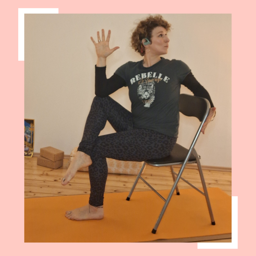 Patricia in einer Variante der Yogaposition "Drehsitz" auf dem Sessel. 